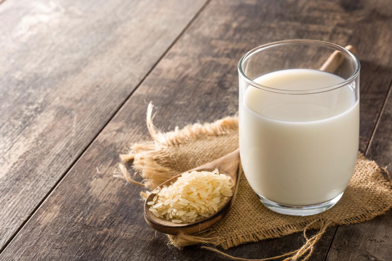 Rice milk in glass and bottle on wooden table
