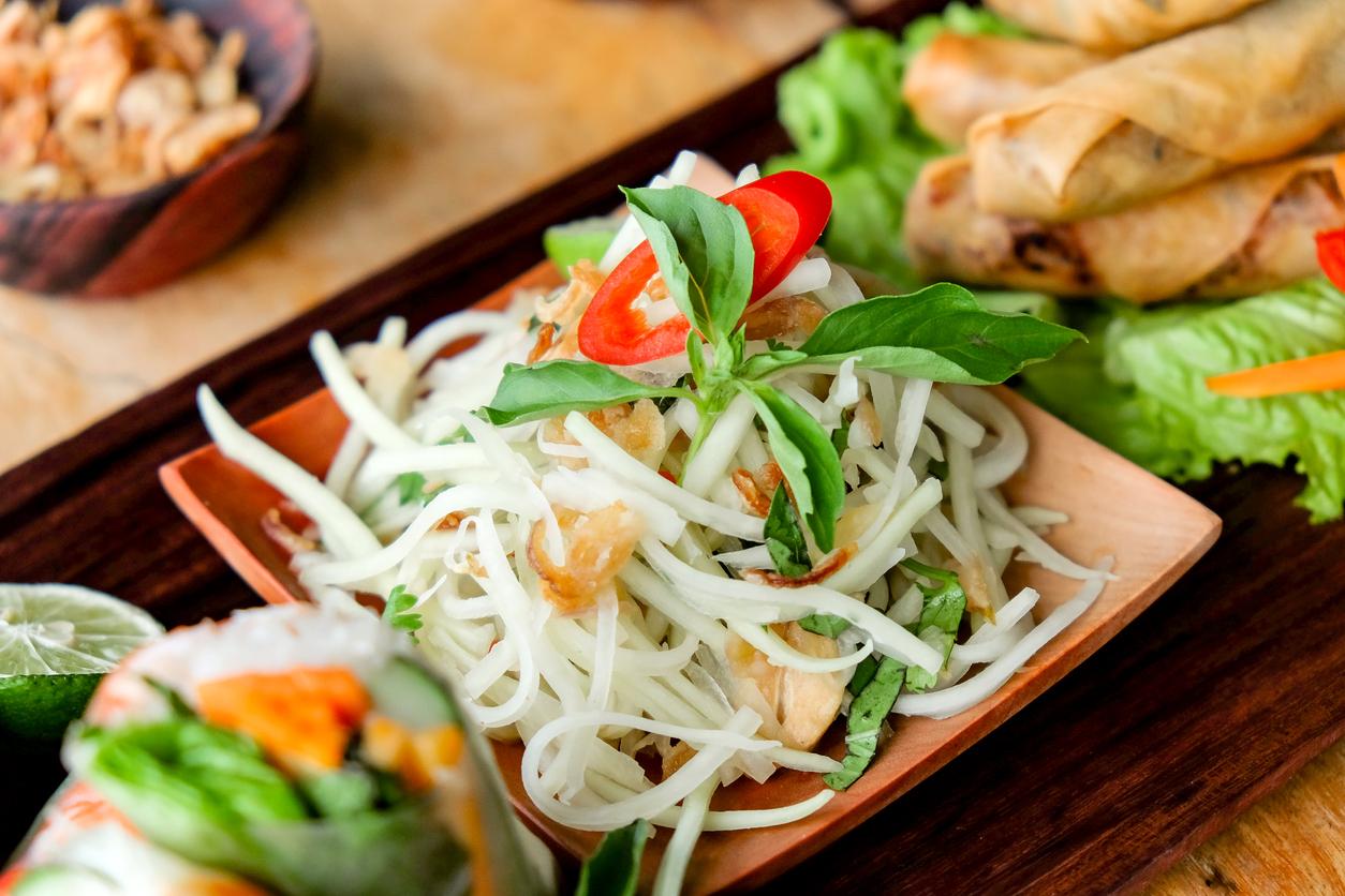 Fresh green papaya salad with fried spring rolls side dish