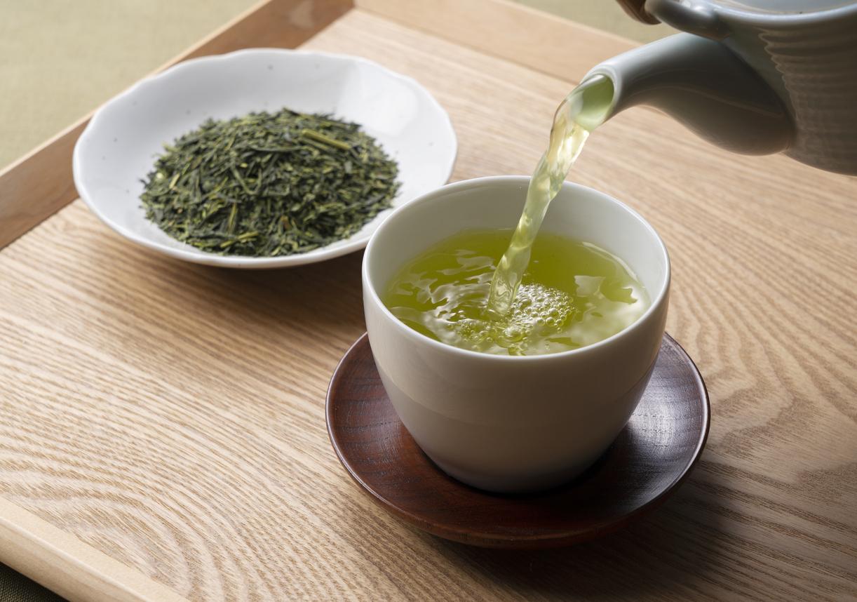Pouring green tea into a teacup. Japanese green tea image