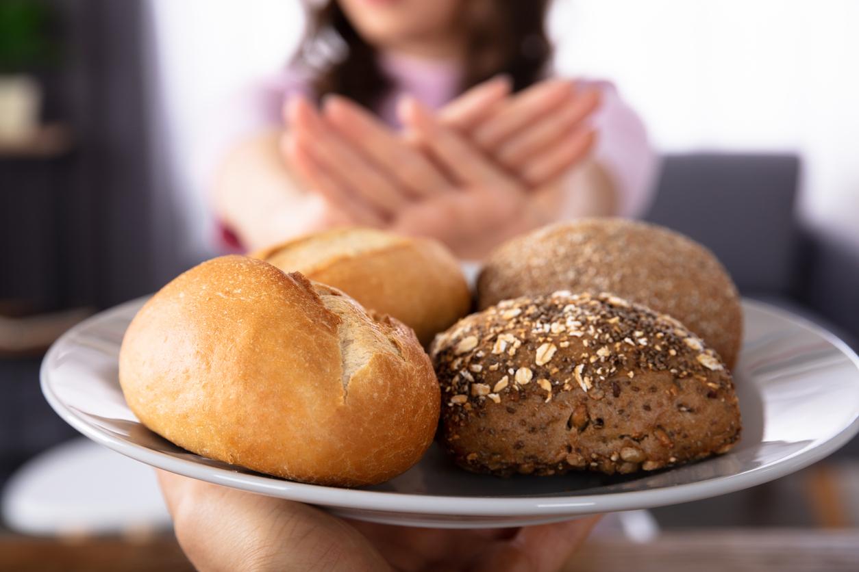 Close-up Of A Woman's Hand Refusing Bread Offered By Person