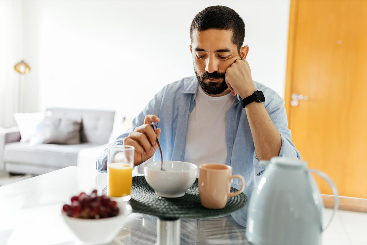 Depressed man at the table suffering from lack of appetite