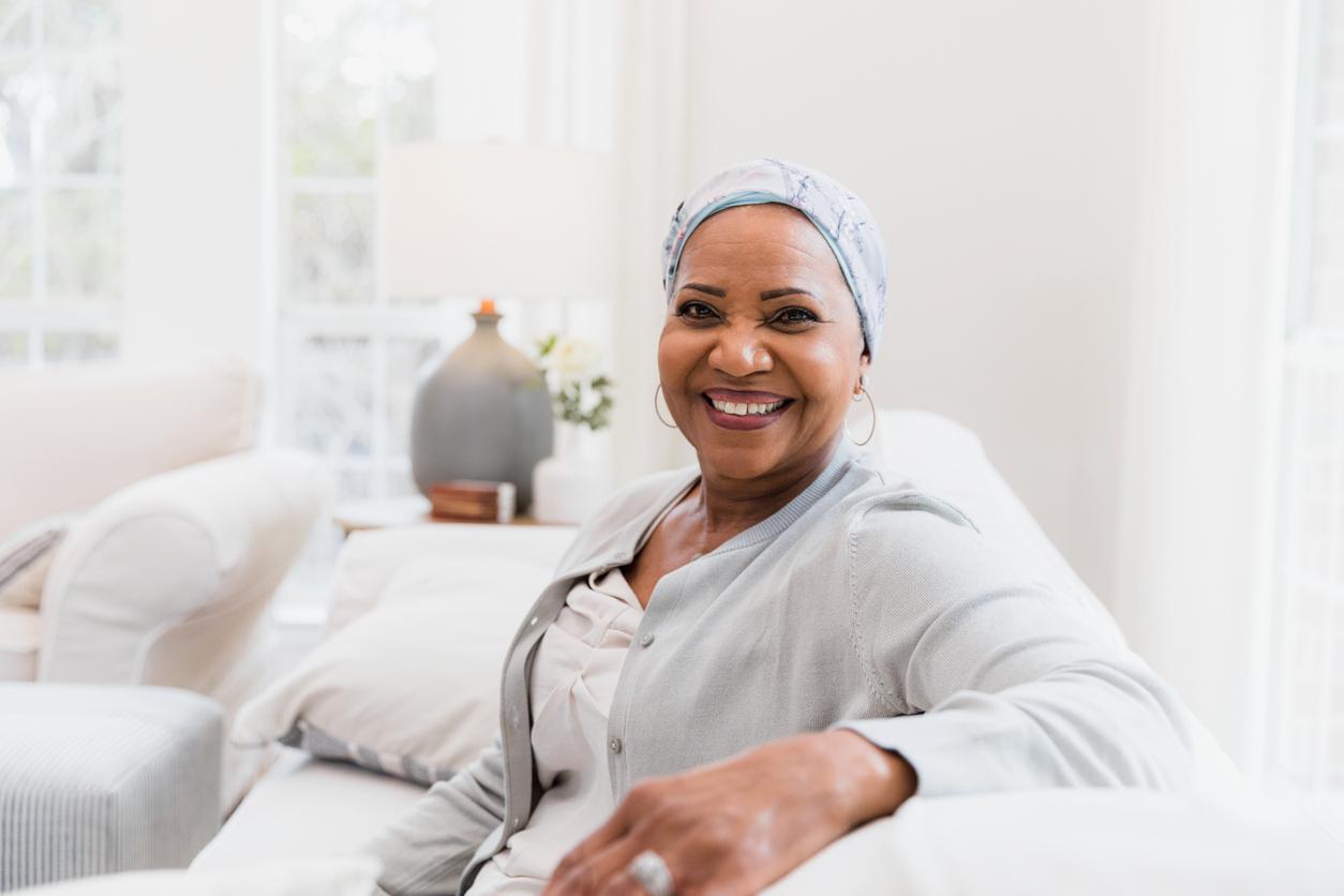 The beautiful woman smiles at the camera to take a photo in her home.