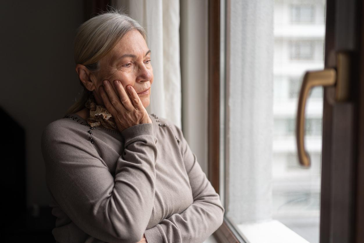Senior Woman Looking Through The Window