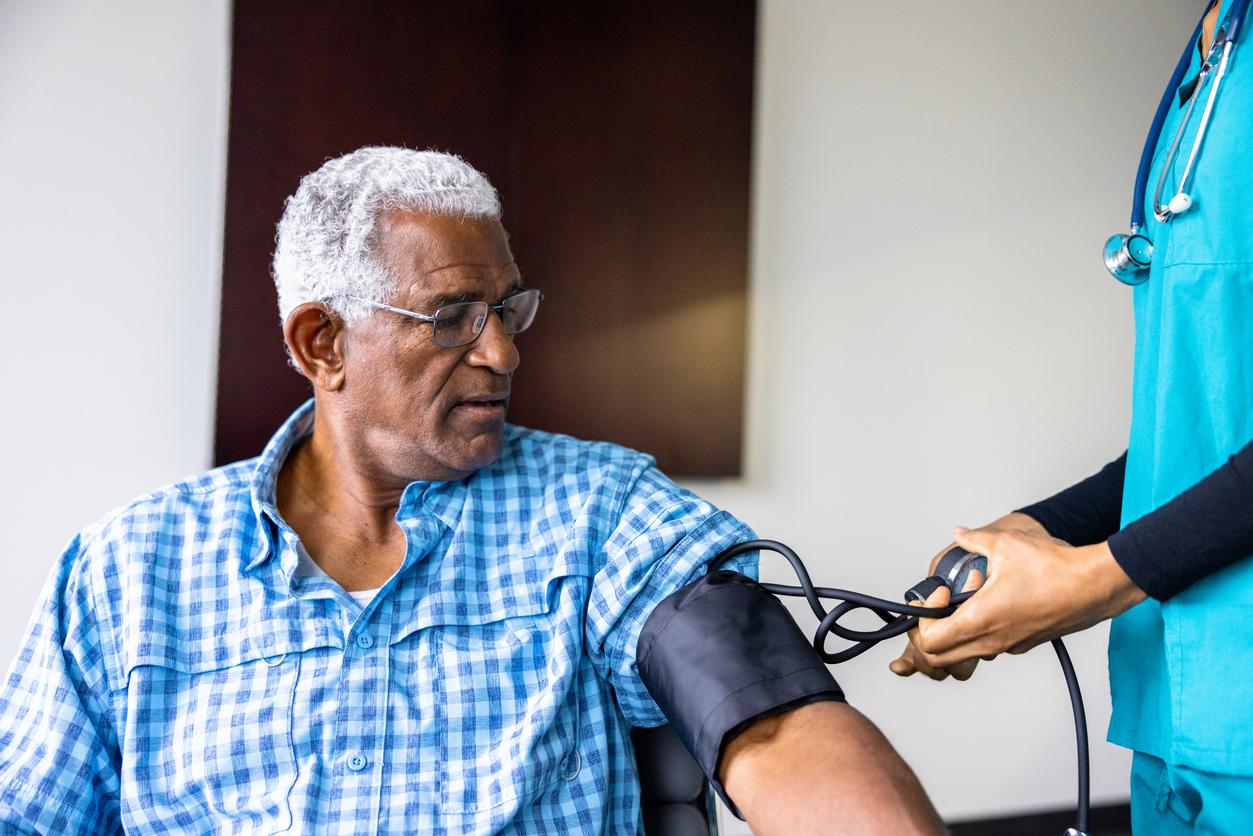 A nurse meeting with a senior black male patient