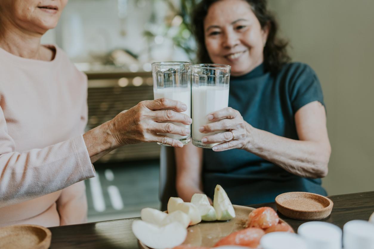 Two retirement person drinking fresh milk and fresh fruits for their good health by suggestion from their personal nutritionist.