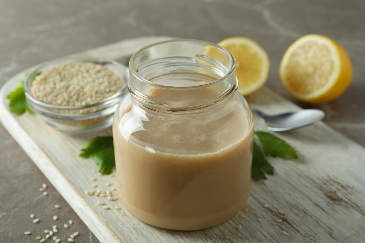 Concept of tasty food with tahini sauce on beige textured background