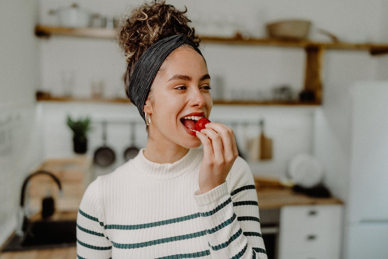 Young woman eating strawberries