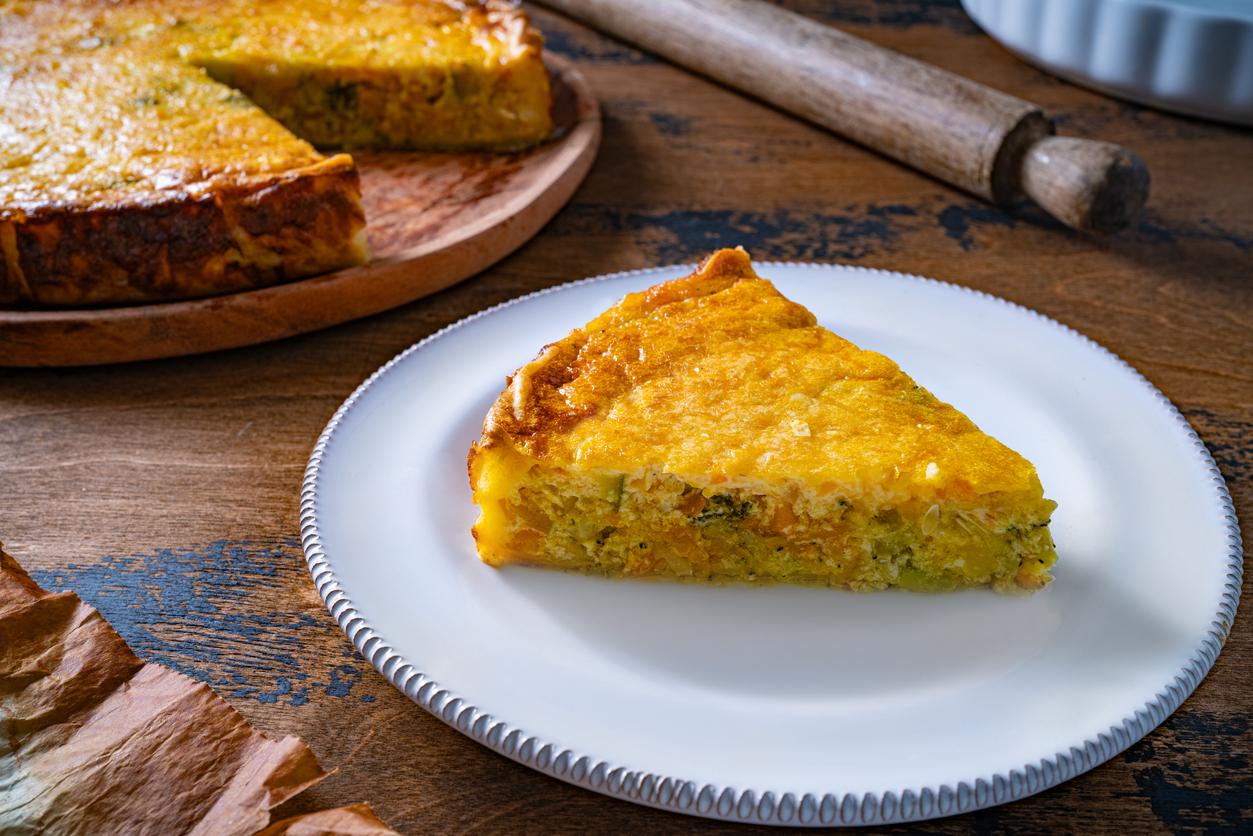 Vegetables quiche slice on plate homemade on wooden rustic table just baked
