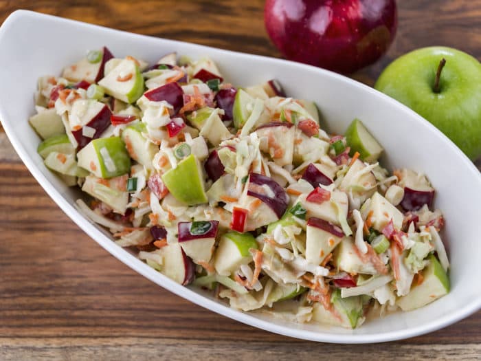 A bowl of fresh-made coleslaw with green and red apples.