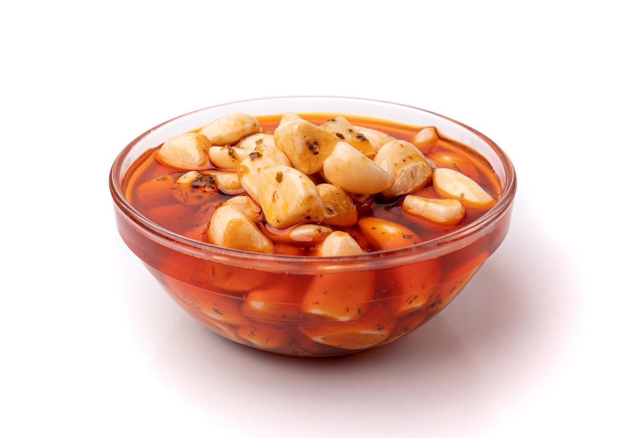 Pickled Garlic Isolated, Fermented Garlic Cloves with Red Chili Pepper, Hot Pickle Vegetable, Spices Garlic Cloves in Oil and Vinegar on White Background
