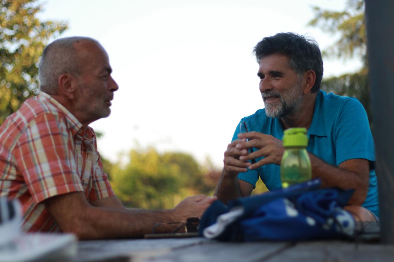 psychologist psychiatrist talk couple of two men touch talk speak smile laugh