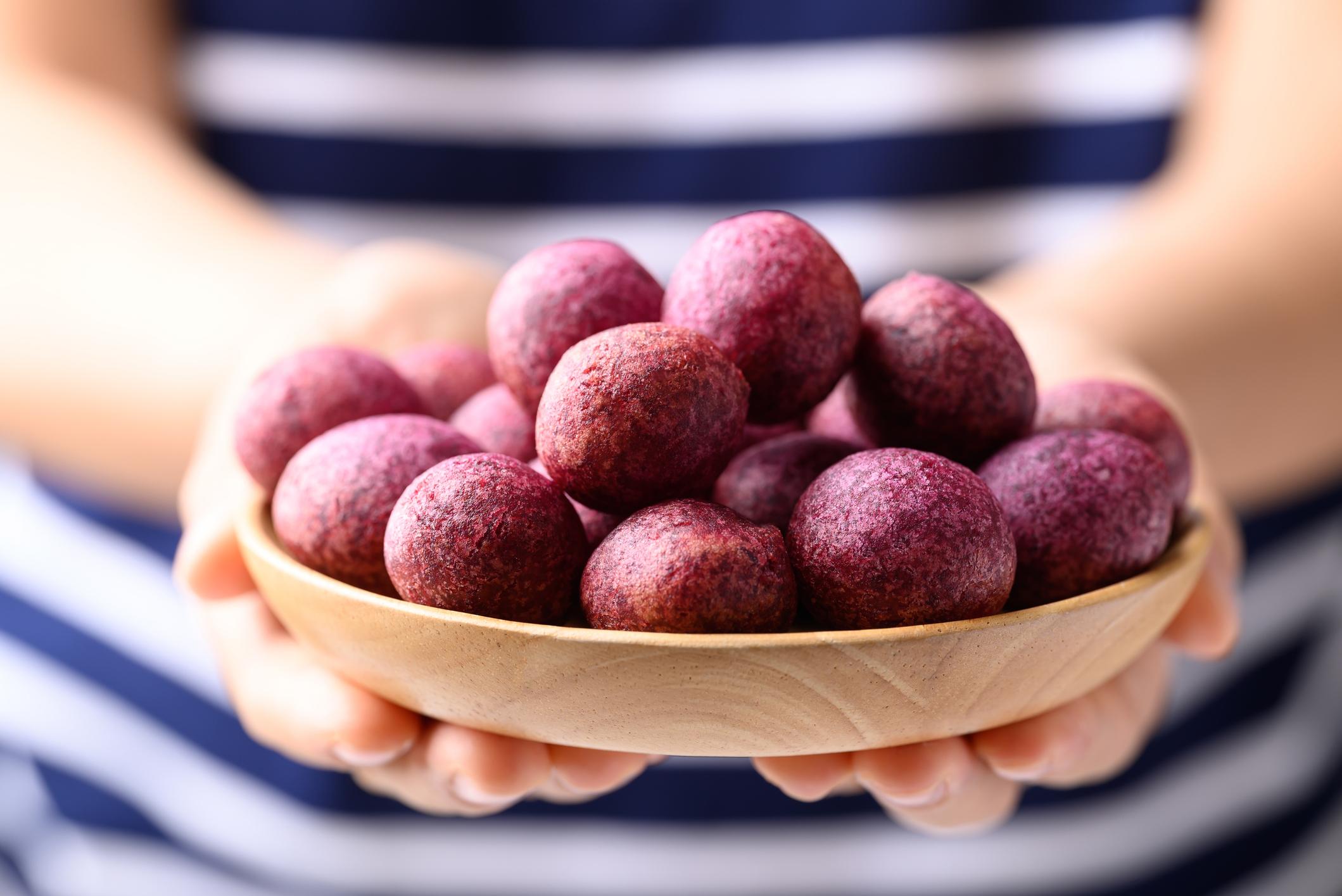 Deep fried purple sweet potato balls with hand, Thai street food
