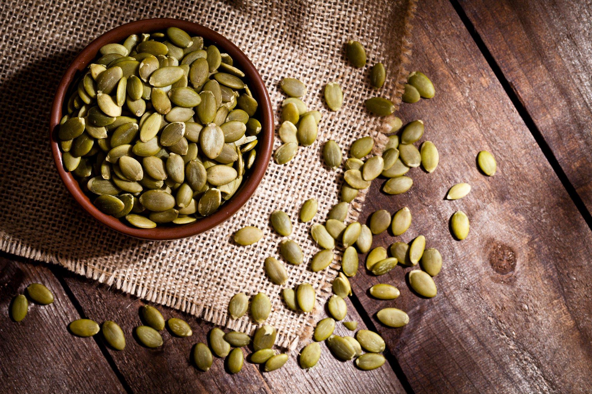 pumpkin seeds in a bowl and on a table